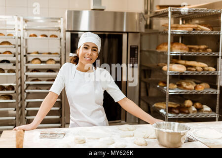 female baker standing at workplace on baking manufacture Stock Photo