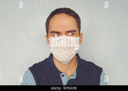 Man in medical mask blue background. quarantine. Young handsome guy in a doctor mask. Epidemiological situation. Protection against pathogenic microbe Stock Photo