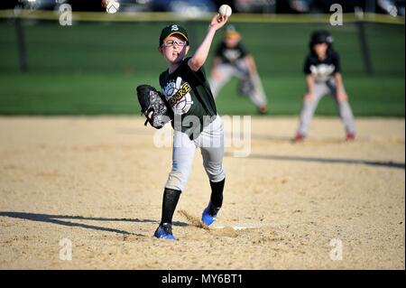 Sycamore, Illinois, USA. A young left-handed pitcher releasing a pitch during an organized community youth baseball game. Stock Photo