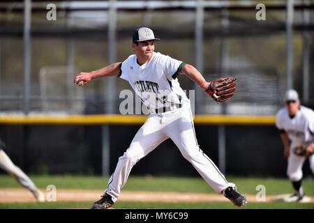 Pitcher delivering a pitch to an opposing hitter during a high school baseball game. USA. Stock Photo