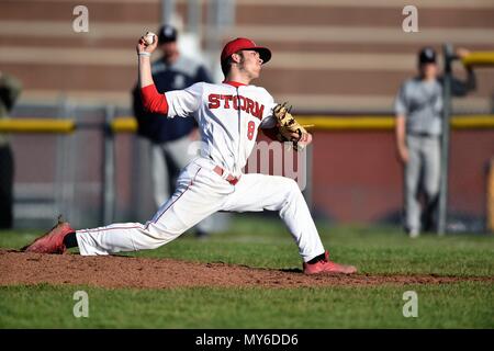 Right-handed pitcher throwing to an opposing hitter during a high school baseball game. USA. Stock Photo