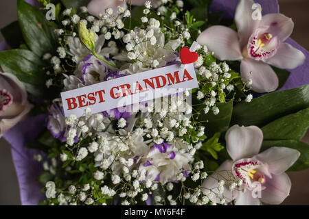 Beautiful flowers gift for Grandparents Day with greeting card. Top view, close-up. Congratulations for loved ones.bouquet of orchids for grandma. Best grandparents ever Stock Photo