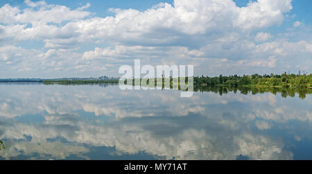 A picturesque panoramic view of the city outskirts on river side against a cloudy sky Stock Photo