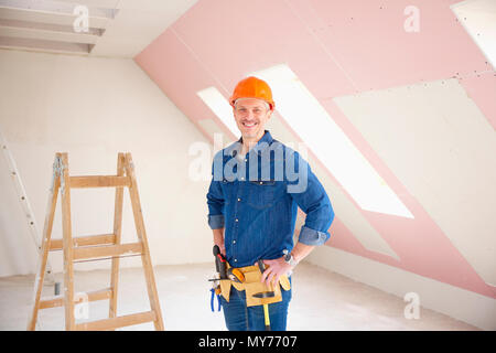 Confident middle aged handyman standing at construction site. Stock Photo
