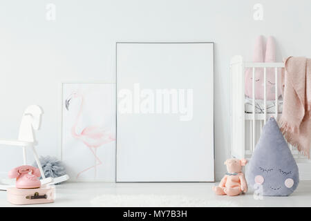 Raindrop pillow and toys in child's bedroom interior with cradle and mockup of poster. Real photo. Place for your graphic Stock Photo