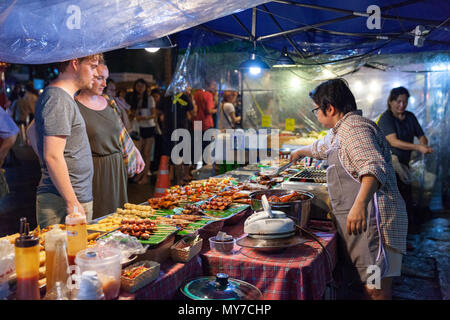 CHIANG MAI, THAILAND - AUGUST 27: Couple buys traditional Thai street food at the Saturday Night Market (Walking Street) on August 27, 2016 in Chiang  Stock Photo