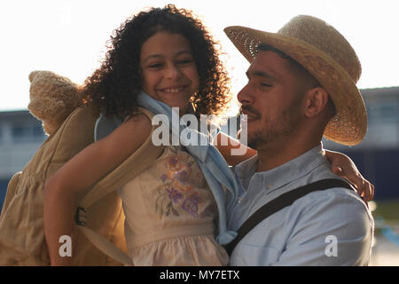 Father carrying daughter in arms Stock Photo