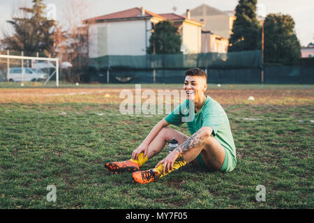 Football player taking break on pitch Stock Photo