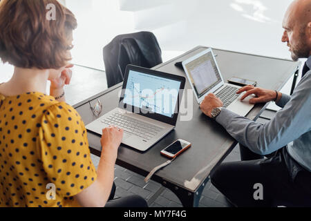 Colleagues at desk using laptops Stock Photo