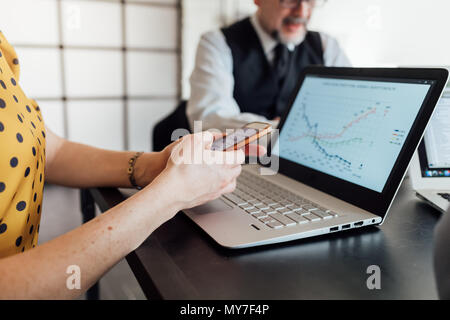 Woman using smartphone and laptop Stock Photo