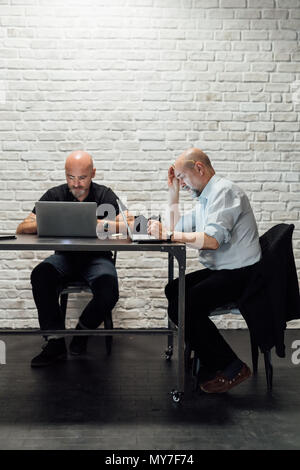 Colleagues as desk using laptops Stock Photo
