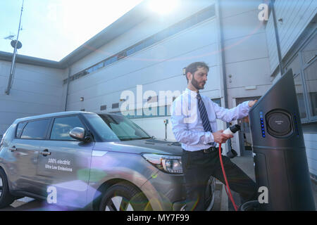 Businessman charging electric car at charging point