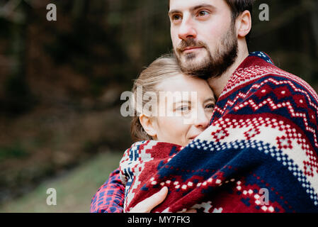 Couple wrapped in blanket Stock Photo