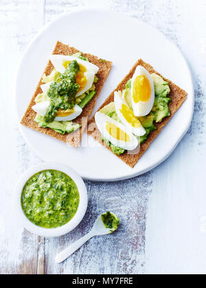 Salsa verde, eggs, avocado, rye crackers Stock Photo