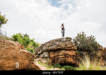 Young female tourist looking out from rock at Bourkes Potholes, Mpumalanga, South Africa Stock Photo