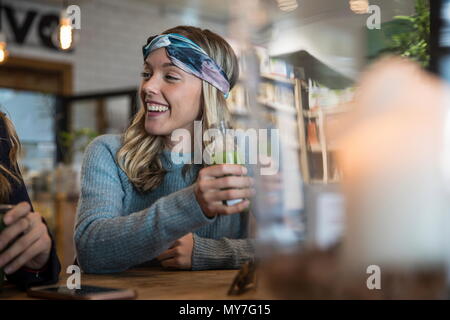 Female friends, sitting in cafe, catching up, drinking smoothies Stock Photo