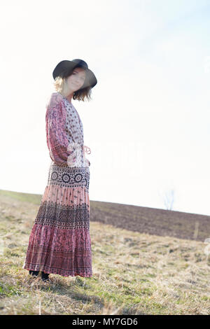 Hippy style woman wearing felt hat in field, portrait Stock Photo