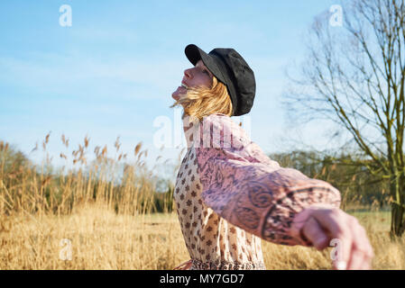 Hippy style woman dancing among reeds Stock Photo