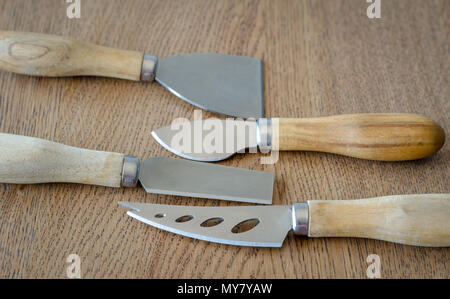 Four cheese knives on wooden background Stock Photo