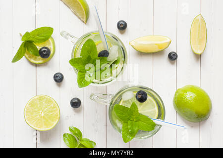 Fresh citrus Lemonade in a glass of lime berry mint blueberries on a light background