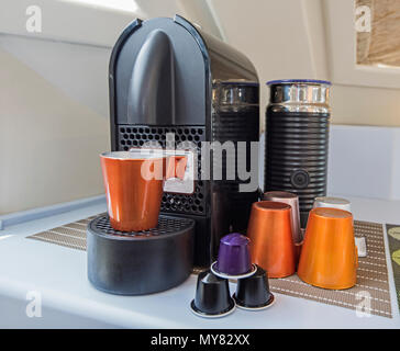 Closeup still life of espresso coffee maker machine with mug cups and capsule pods Stock Photo