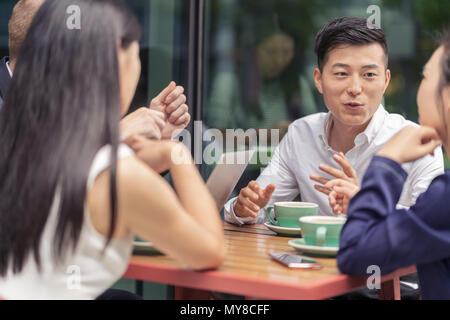 Group of businesspeople, having meeting at cafe, outdoors Stock Photo