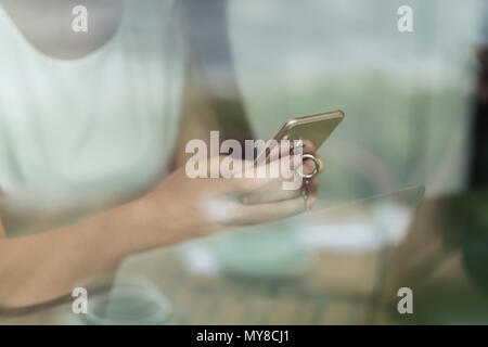 Businesswoman using smartphone and laptop, mid section, close-up Stock Photo