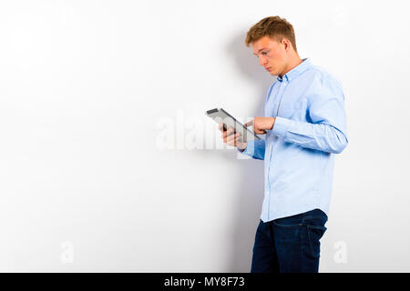 Serious young male executive using digital tablet against gray background Stock Photo