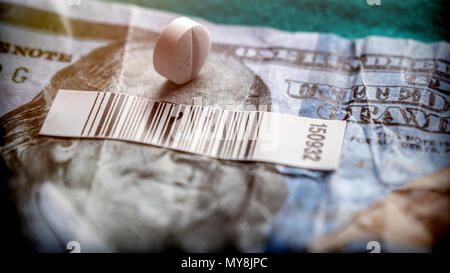 Bar code and a white pill on a ticket of dollar, concept of sanitary copayment Stock Photo