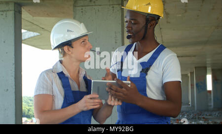 Engineers on building site using digital tablet and talking Stock Photo