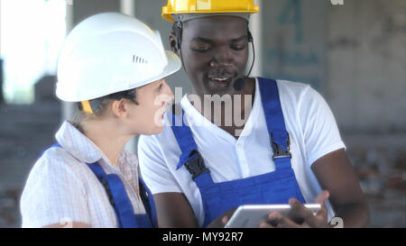 Confident female engineer or architect discussing construction issues with male colleague Stock Photo