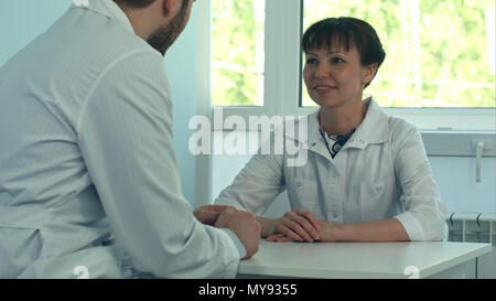 Two doctors discussing and working together in a medical office Stock Photo