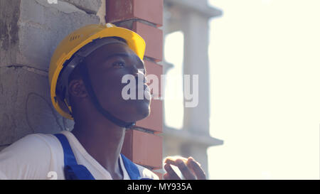 Construction afro-american worker take a break eating a sandwich Stock Photo