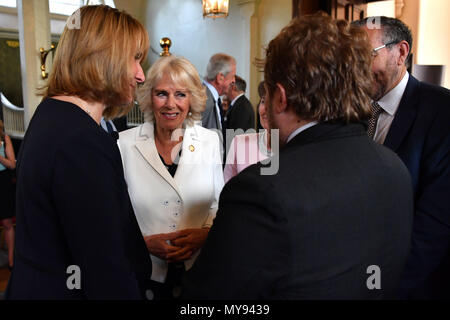 The Duchess of Cornwall (centre) speaks to Andreas Mershin (2nd right) of the charity Medical Detection Dogs during the 10th anniversary celebration of the charity at the Royal Mews in London. Stock Photo