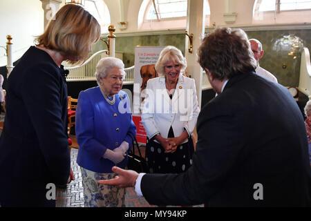 Queen Elizabeth II and the Duchess of Cornwall speak to Andreas Mershin (right) of the charity Medical Detection Dogs during the 10th anniversary celebration of the charity at the Royal Mews in London. Stock Photo