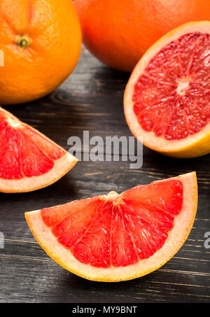 Several sliced grapefruit on dark table Stock Photo