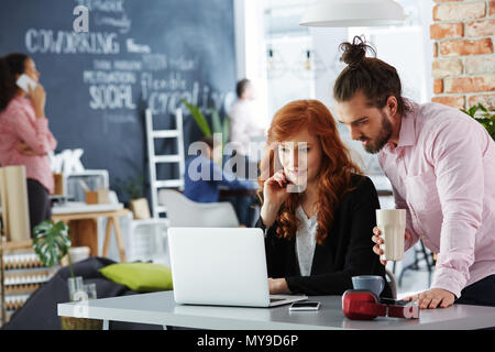 Creative man and woman working together, using laptop Stock Photo