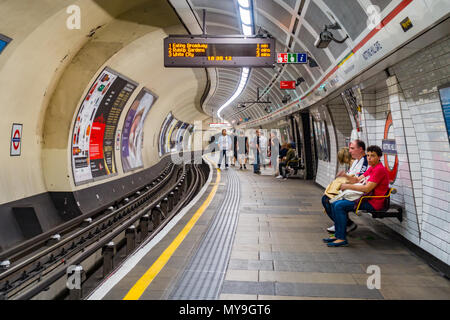 Passengers wait on the platform at Notting Hill Gate London Underground Station. Stock Photo