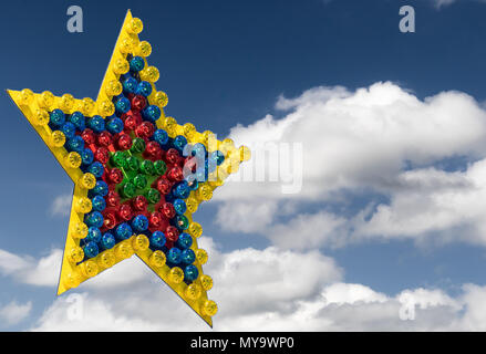 Large colorful star of differently colored lamps exempted in front of a blue sky with clouds, illustration Stock Photo