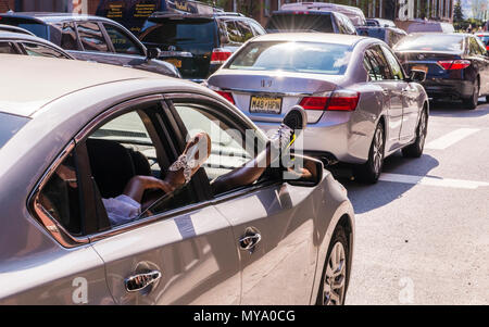 Man and woman relaxing in car, resting feet out of open car window, Downtown Manhattan, New York City, USA Stock Photo