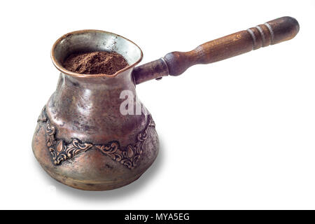 An old coffee maker made in the Middle East. Copper cup and wooden handle. Turkish coffee . Isolated photo on a white background. Stock Photo