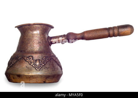 An old coffee maker made in the Middle East. Copper cup and wooden handle. Turkish coffee . Isolated photo on a white background. Stock Photo