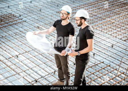 Builders with drawings at the construction site Stock Photo