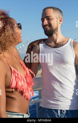 Mixed raced couple on sunny beach in summer vacation Stock Photo