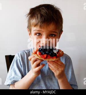 A portrait of a young boy (6 yr old) eating a healthy breakfast of fruit and toast