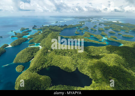 Aerial view of curious patterns of coral reefs, coral atolls, and vegetation on islands as storm comes near Stock Photo