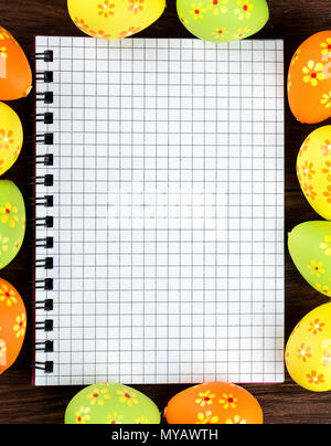 Blank notebook surrounded by Easter eggs for congratulations Stock Photo