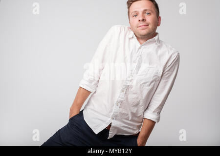 Caucasian shy man hiding hands in pockets. Stock Photo