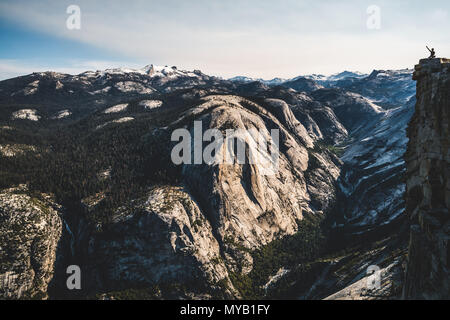 A tiny, lonely hiker on top of Half Dome in Yosemite National Park. Stock Photo