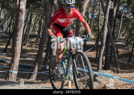 Male Turkish cyclist competes in an international mountain bike race in a forest in the Greek village of Molyvos on the island of Lesvos Stock Photo